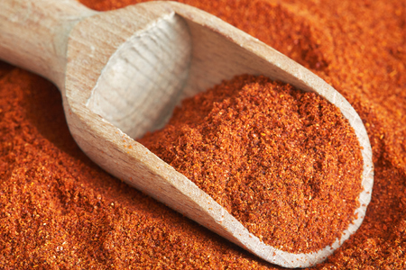 Closeup of red paprika powder with wooden scoopの写真素材