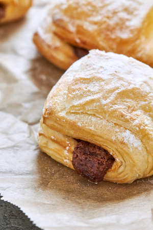 Puff pastry dessert with chocolate filling on baking paperの写真素材