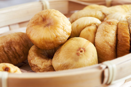 Dried figs in woven basket, closeup with selective focus
