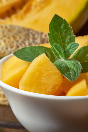 Sweet ripe cantaloupe melon cut and served with mint leavesの写真素材