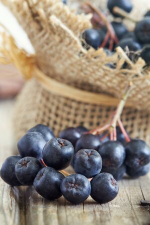 Aronia berries (black chokeberry) on rustic wooden backgroundの写真素材