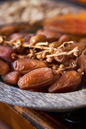 Pile of fresh dried dates in a wooden plateの写真素材