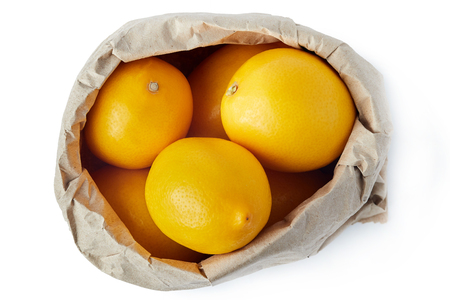 Lemons in brown paper grocery bag isolated on white backgroundの写真素材