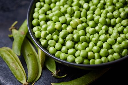 Fresh raw organic green peas (Pisum sativum) in bowlの写真素材