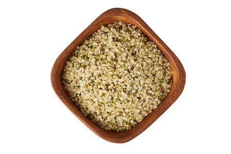 Organic shelled hemp seeds in wooden bowl  isolated on white backgroundの写真素材
