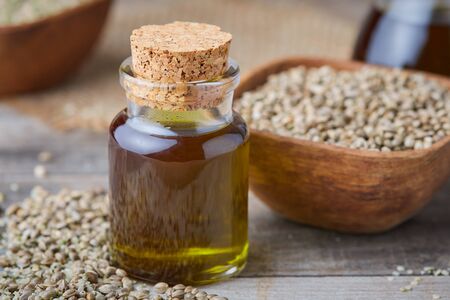 Organic hemp oil and hemp seeds on rustic backgroundの写真素材