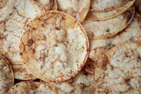 Brown rice chips in wooden bowl. Healthy crispy snackの写真素材