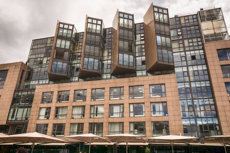 Oslo, Norway - July 18, 2016: People enjoying the summer sunshine beside the al fresco restaurants and modern apartment buildings of Aker Brygge, the popular leisure district on the Oslo waterfront overlooking the marinas of Oslofjrden, Norway.のeditorial素材