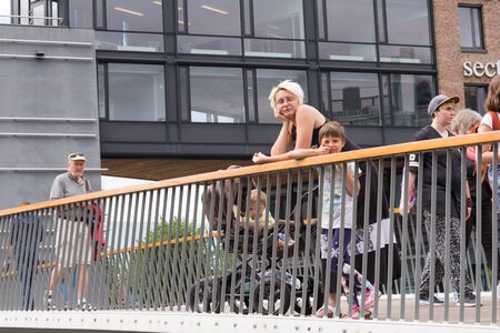 Oslo, Norway - July 18, 2016: People enjoying the summer sunshine beside the al fresco restaurants and modern apartment buildings of Aker Brygge, the popular leisure district on the Oslo waterfront overlooking the marinas of Oslofjrden, Norway.のeditorial素材