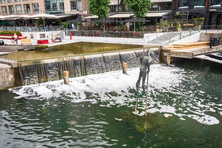 Oslo, Norway - July 18, 2016: People enjoying the summer sunshine beside the al fresco restaurants and modern apartment buildings of Aker Brygge, the popular leisure district on the Oslo waterfront overlooking the marinas of Oslofjrden, Norway.のeditorial素材