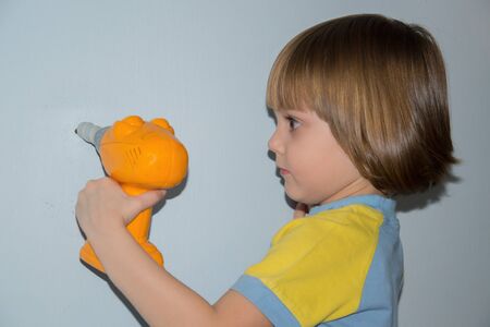 Beautiful little girl using drillの写真素材