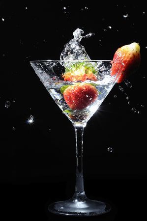 strawberry splashing into martini cocktail drinkの写真素材