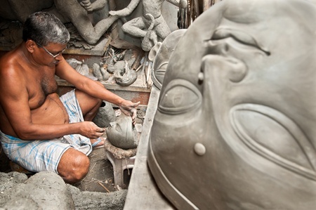 CALCUTTA - AUGUST 15, 2011: An artisan creates heads of clay idols of goddesses on August 15, 2011 in Kumartuli, Calcutta, India. The idols are made for the Hindu festival of Dasara.のeditorial素材