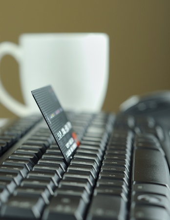 Internet shopping using credit card, coffee cup and mouse in the backgroundの写真素材