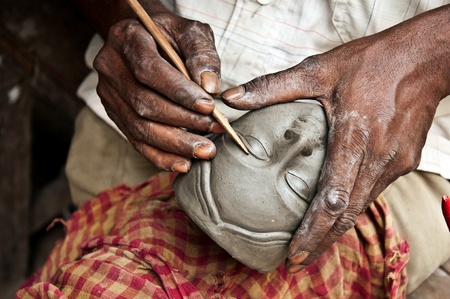 An artisan creates the head of a goddess for Durga puja festival in Bengal, Indiaの写真素材