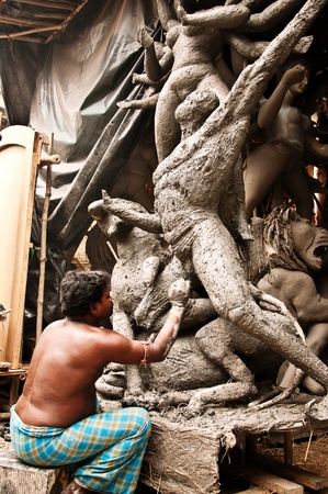 KOLKATA, INDIA 24TH SEP 2010: An unidentified clay artisan of Kumartuli creates a gigantic sculpture of goddess Durga to be sold for the festival of Dasara. Dasara is a popular festival of Hindu religion where goddess Durga and her deities are worshipped.のeditorial素材