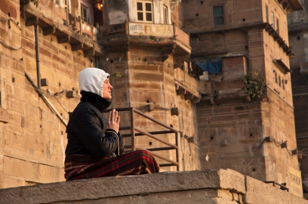 VARANASI, INDIA - FEBRUARY 20, 2012: An unidentified monk prays to the sun god at dawn on the auspicious Maha Shivaratri festival on February 20, 2011 at Varanasi, Uttar Pradesh, India.のeditorial素材
