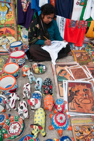 SHANTINIKETAN, INDIA - DECEMBER 24: An Indian craftswoman creates colorful handicraft items for sale during the annual Poush Mela fair on December 24, 2012 in Shantiniketan, West Bengal, India.のeditorial素材