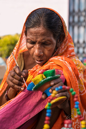 KOLKATA, INDIA - DECEMBER 7: An Indian craftswoman creates colorful handicraft items for sale during the annual State Handicrafts Expo 2014 on December 7, 2014 in Kolkata, West Bengal, India.のeditorial素材