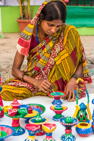 KOLKATA, INDIA - NOVEMBER 24: An Indian craftswoman paints on colorful handicraft items for sale during the annual State Handicrafts Expo 2015 on November 24, 2015 in Kolkata, West Bengal, India.のeditorial素材