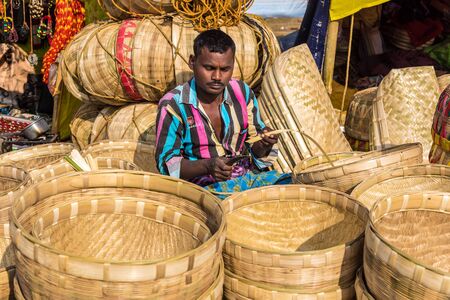 SHANTINIKETAN, INDIA - DECEMBER 26: An Indian craftsman weaves cane baskets for sale during the Poush Mela fair on December 26, 2015 in Shantiniketan, West Bengal, India.のeditorial素材