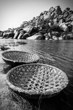 Traditional rural coracle boats on Tungabhadra river in Hampi in black and white.の写真素材