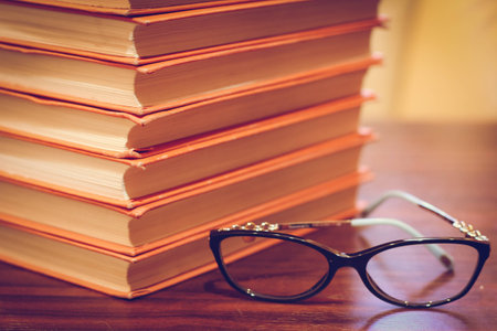 A books with spectacles on a wooden table