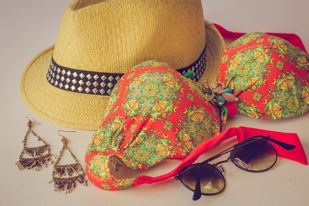 Summer accessories on the table. Straw slop, swimsuit bando, sunglasses and earrings. Set of accessories for holidaysの写真素材