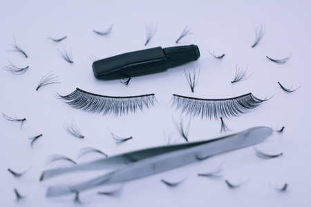 False eyelash, bundles of eyelashes, tweezers, glue tube, isolated on white background. Items for women's beauty.の写真素材