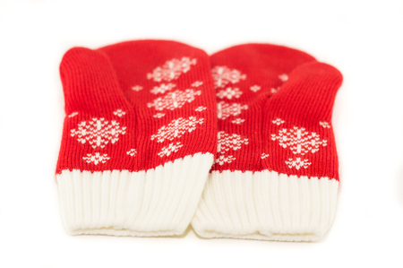 Christmas red knitted mittens with snowflake motives on white background. Pair of red woolen gloves, isolate on whiteの写真素材