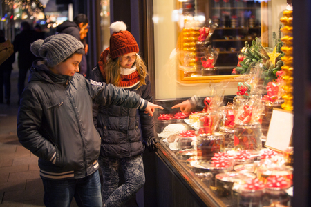 Children stood before the shop-window with a Christmas motive and point at the presentsの写真素材