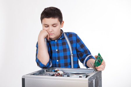 A boy in the blue shirt tries to repair a PCの写真素材