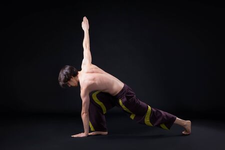 Yoga workout in the studio on black backgroundの写真素材
