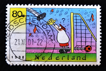NETHERLANDS - CIRCA 1998: A stamp printed in Netherlands showing a soccer goalie cartoon, circa 1998の写真素材