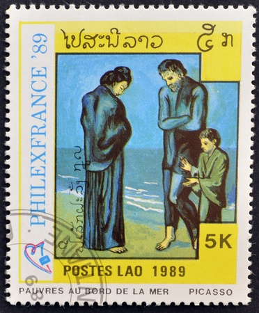 LAOS-CIRCA 1989: A stamp printed in the Laos shows painting "poor in the sea" by Pablo Picasso, circa 1989のeditorial素材