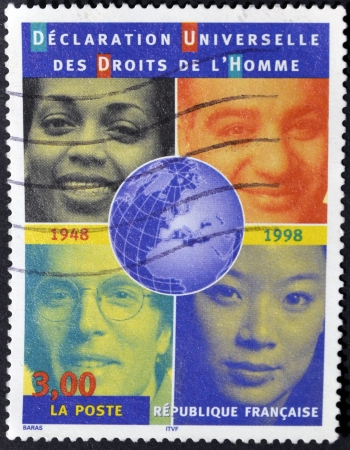 FRANCE - CIRCA 1998: A stamp printed in France shows the faces of people of different races in reference to the universal declaration of human rights, circa 1998の写真素材