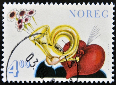NORWAY - CIRCA 1999: A stamp printed in norway shows person with heart-shaped head with a trumpet playing the leaving flowers, circa 1999のeditorial素材