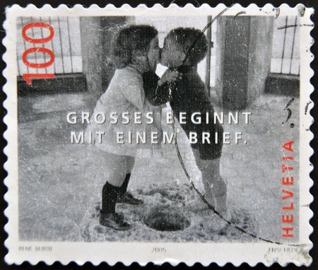 SWITZERLAND - CIRCA 2005: A stamp printed in Switzerland shows image to two boys kissing, great start with a brief, circa 2005のeditorial素材
