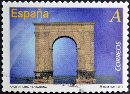 SPAIN - CIRCA 2012: A stamp printed in Spain dedicated to arches and monumental gates, shows Arco de Bara at Tarragona, circa 2012の写真素材
