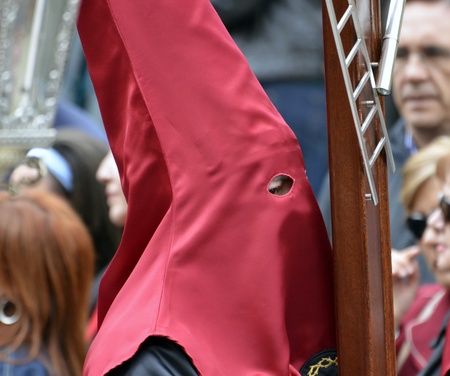 Nazarene wearing the cross guide, typical Easter procession in Granada, Spain