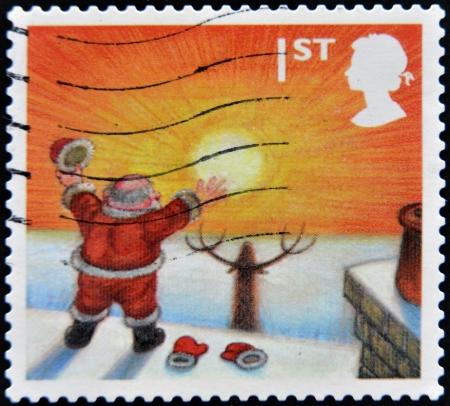 UNITED KINGDOM - CIRCA 2004: A stamp  printed in Great Britain shows image of Santa Claus looking at rising sun, circa 2004 のeditorial素材