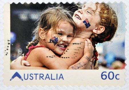 AUSTRALIA - CIRCA 2011: A stamp printed in australia shows embrace of friendship between two girls with the Australian flag in the face, circa 2011のeditorial素材