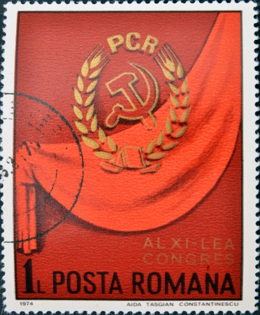 ROMANIA - CIRCA 1974: A stamp printed in Romania shows Communist party symbol on red background, circa 1974. のeditorial素材