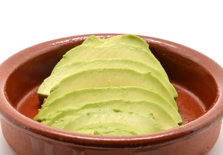 avocado cut into clay bowl