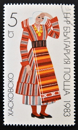 BULGARIA- CIRCA 1983: A stamp printed in Bulgaria shows young woman in traditional Bulgarian costume, circa 1983の写真素材