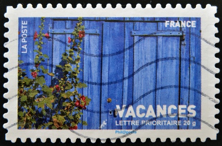 FRANCE - CIRCA 2007: stamp printed in France shows wooden fence and hoollyhooks, circa 2007の写真素材