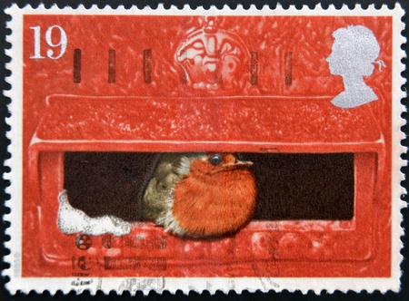 UNITED KINGDOM - CIRCA 1996  a stamp printed in Great Britain shows image of a robin sitting in a postbox, circa 1996 の写真素材