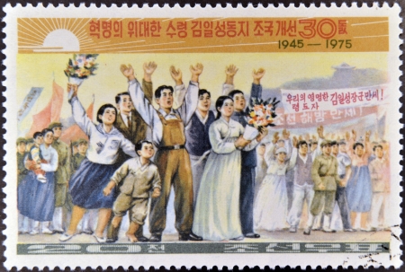 NORTH KOREA - CIRCA 1975: A stamp printed in Korea shows people celebrating the anniversary of the founding of North Korea in 1945, circa 1975のeditorial素材
