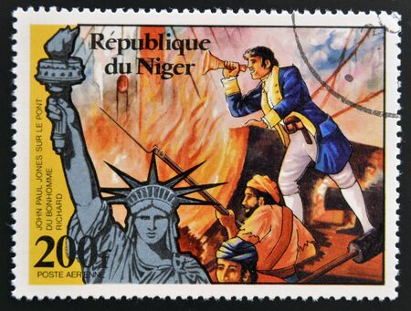 NIGER - CIRCA 1976: stamp printed in Niger shows Statue of Liberty and john paul jones, circa 1976 のeditorial素材