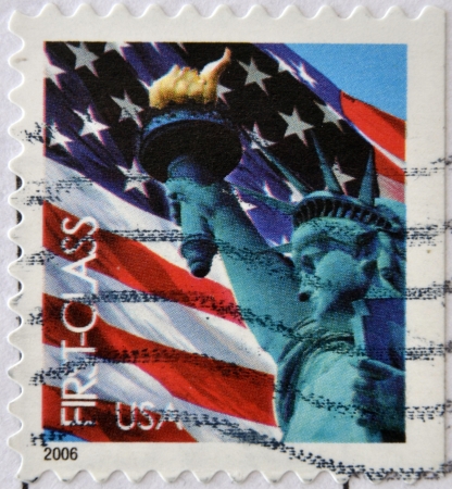 UNITED STATES OF AMERICA - CIRCA 2006: A stamp printed in USA shows the The Statue of Liberty and the american flag, circa 2006. のeditorial素材